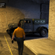 A man in a yellow shirt walks toward a dark green truck in an underground bunker.